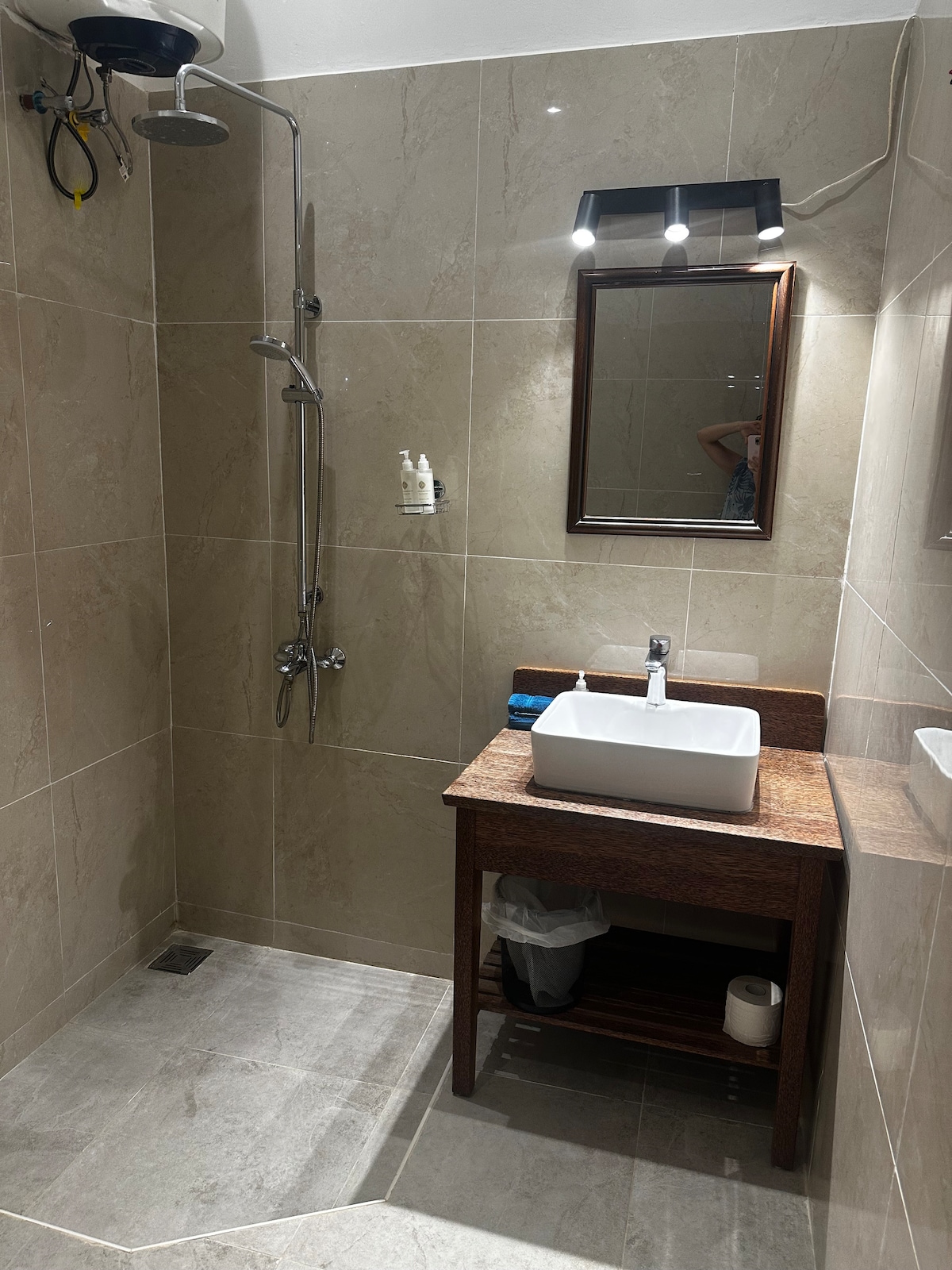 Bathroom with beige tiles, wooden vanity and vessel sink